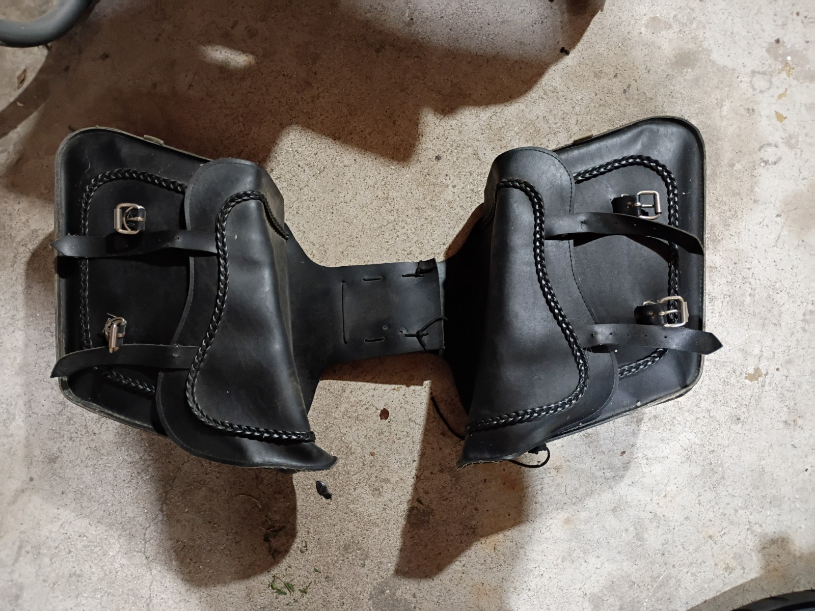 willie and max black leather throw over saddle bags with braided design.